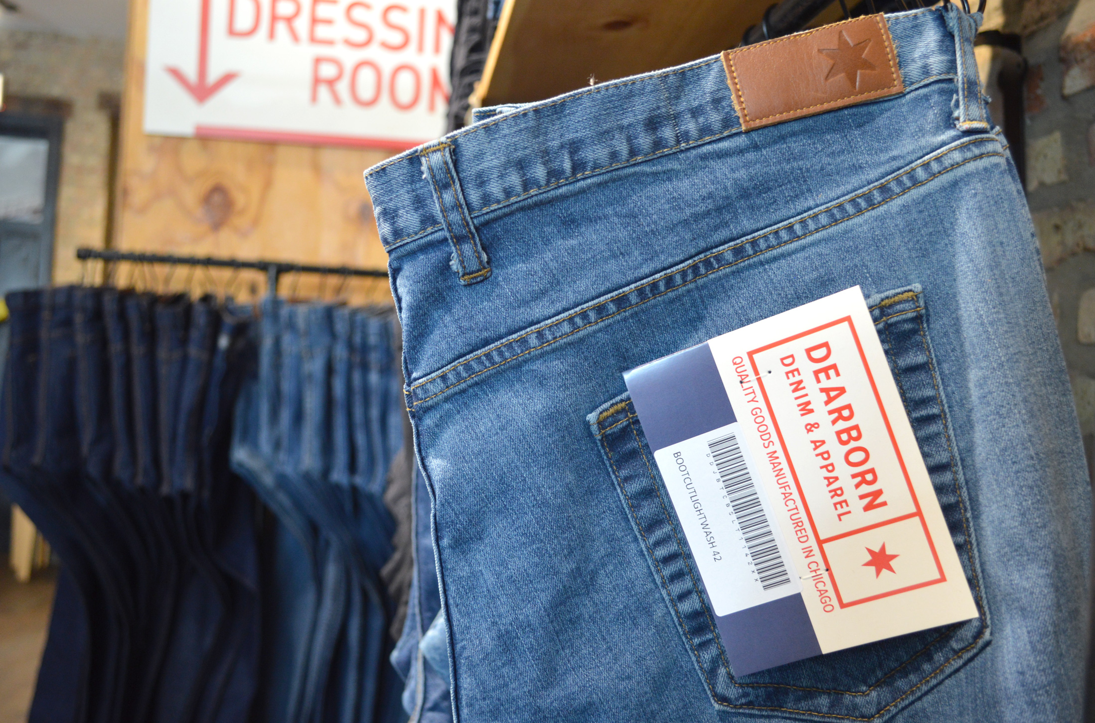 jeans hanging on a clothes rack inside of a retail store